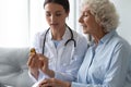 Young female doctor prescribe medicine bottle to old grandma patient Royalty Free Stock Photo