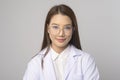 Young female ophthalmologist with glasses holding eye chart over blue background studio, healthcare concept Royalty Free Stock Photo