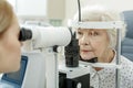 Young female ophthalmologist using apparatus Royalty Free Stock Photo