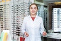 Young female optician offering professional help in shop