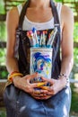 Young female painter artist holding a bunch of dirty used paintbrushes. Funky lifestyle creative hobbies background. Royalty Free Stock Photo