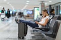 Young female passenger at the airport, using her tablet Royalty Free Stock Photo