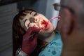 Young Female patient with open mouth having dental inspection and treatmant at dentist office. Senior man doctor dentist Royalty Free Stock Photo