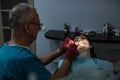 Young female patient with senior male dentist having a dental treatment.