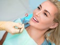 Young female patient visiting dentist office. Beautiful woman with healthy straight white teeth sitting at dental chair. Royalty Free Stock Photo