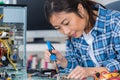 Young female pc technician welding pc parts Royalty Free Stock Photo