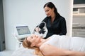 Young female performs effective RF lifting procedure on shoulder area