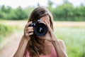 Young female photographer taking a photo directly at you Royalty Free Stock Photo
