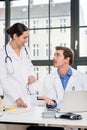 Young female physician asking for advice from her experienced male colleague Royalty Free Stock Photo