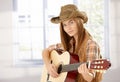 Young female playing guitar in western style