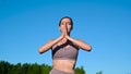 Young female practicing yoga against the sky on a sunrise. Pretty slim woman performs an exercise. Healthcare, meditaion