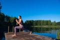 Young female practicing yoga against the sky on a sunrise. Pretty slim woman performs an exercise. Healthcare, meditaion
