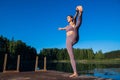 Young female practicing yoga against the sky on a sunrise. Pretty slim woman performs an exercise. Healthcare, meditaion