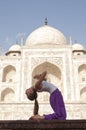 Young female practising Ustrasana or Camel Pose at Taj Mahal