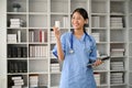 Young female professional doctor holding a bottle of pills while standing in her office room Royalty Free Stock Photo