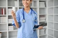 Young female professional doctor holding a bottle of pills while standing in her office room Royalty Free Stock Photo