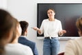 Young female professor explaining subject to classroom full of students Royalty Free Stock Photo