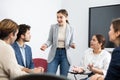 Young female professor explaining subject to classroom full of students Royalty Free Stock Photo