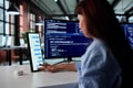 Young Female Programmer Multitasking On Multiple Screens Royalty Free Stock Photo