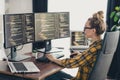 Young female programmer working remotely on multiple screens in a home office creating software solutions with precision Royalty Free Stock Photo