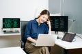 Young female programmer working with tablet and screen displaying code. Modern tech office setup, great for software, coding, IT Royalty Free Stock Photo