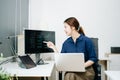 Young female programmer working with tablet and screen displaying code. Modern tech office setup, great for software, coding, IT Royalty Free Stock Photo