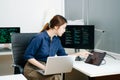 Young female programmer working with tablet and screen displaying code. Modern tech office setup, great for software, coding, IT Royalty Free Stock Photo