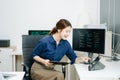Young female programmer working with tablet and screen displaying code. Modern tech office setup, great for software, coding, IT Royalty Free Stock Photo