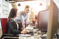 Young female programmers working together on desktop computer in office. Royalty Free Stock Photo