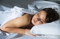 Young female in pygamas is sleeping on bed