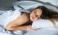 Young female in pygamas is sleeping on bed