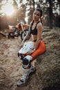 Young female racer with semi naked torso sitting on a grass at sunset in the woods Royalty Free Stock Photo