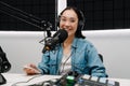 Young female radio host using microphone and headphones in studio Royalty Free Stock Photo