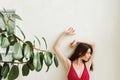 Young female in red bralette with her hands on the white wall Royalty Free Stock Photo