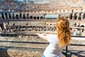 Young female redhead tourist inside the Colosseum in Rome