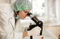 Young female researcher with microscope