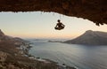 Young female rock climber hanging on rope in asana position Royalty Free Stock Photo