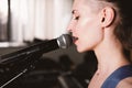 young female rock singer with microphone, singing. side view. close up. woman with short hair on a stage. live music Royalty Free Stock Photo