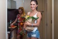 Young female roommates in kitchen cooking vegetable salad
