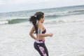 Young female runner jogging on the beach. Beautiful fit mixed ra Royalty Free Stock Photo