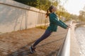 Attractive young woman stretching her arms and legs before her early morning exercise. Royalty Free Stock Photo