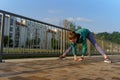 Attractive young woman stretching before her early morning run along the embankment of river. Royalty Free Stock Photo