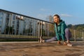 Attractive young woman stretching her arms before her early morning run along the embankment of river. Royalty Free Stock Photo