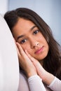 Young female sad and thinking on sofa Royalty Free Stock Photo