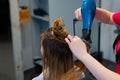 Young female at a salon blow drying their hair with a professional hairdryer Royalty Free Stock Photo