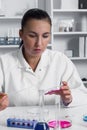 Young Female Scientist Analyzing Sample In Laboratory.laboratory assistant analyzing a sample.