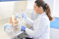 Young female scientist looking through a microscope in a laboratory doing research, microbiological analysis, medicine Royalty Free Stock Photo