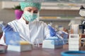 A young female scientist in protective gear is focused while working in a laboratory. Science, covid 19 virus, lab, people Royalty Free Stock Photo