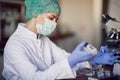 A young female scientist in a protective gear preparing samples for analyses at the laboratory. covid 19, virus, corona, Science, Royalty Free Stock Photo