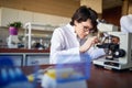 A young female scientist puts sample to the microscope at the university laboratory. Science, chemistry, lab, people